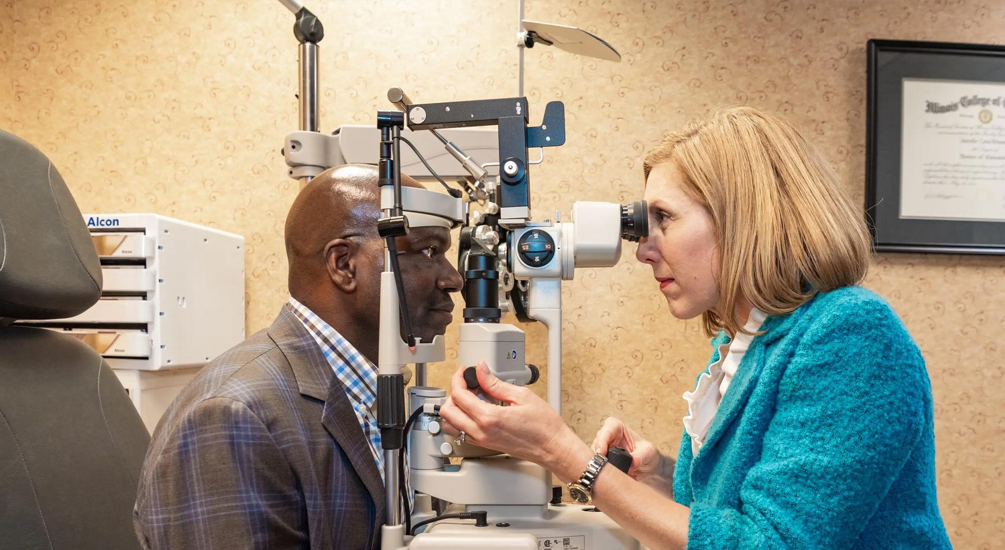 A woman is assisting a man with an eye exam using a machine, likely at an optometrist s office.