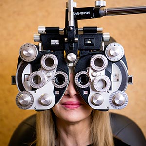 The image shows a person wearing an optical device, likely a pair of glasses, with their eyes visible through the lenses, focusing on something outside the frame.