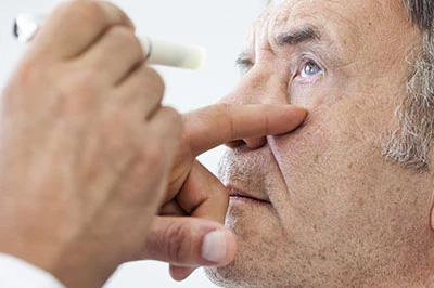 The image shows a man receiving a medical treatment with a syringe being inserted into his nose by a healthcare professional.