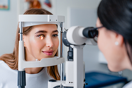 An eye exam being conducted by an optometrist on a patient.